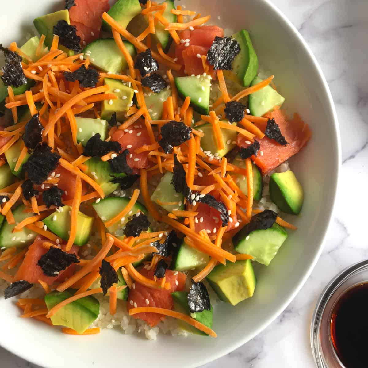 bowl of smoked salmon sushi bowl with avocado, salmon, carrots and rice